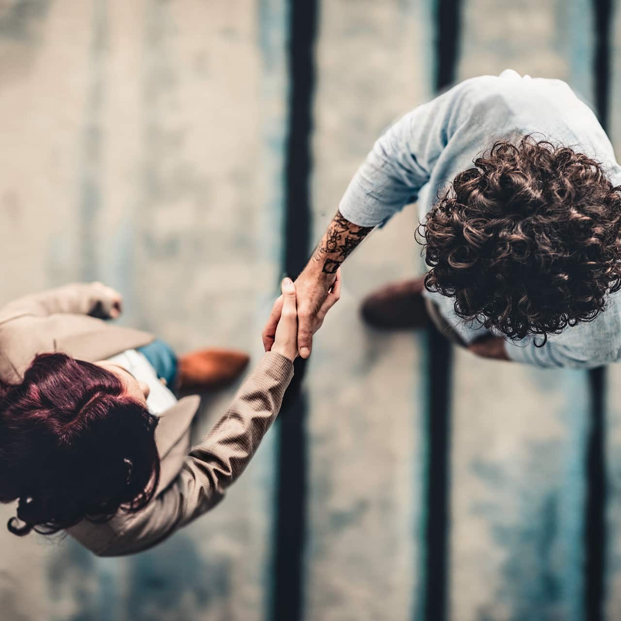 An overhead view of 2 people shaking hands.